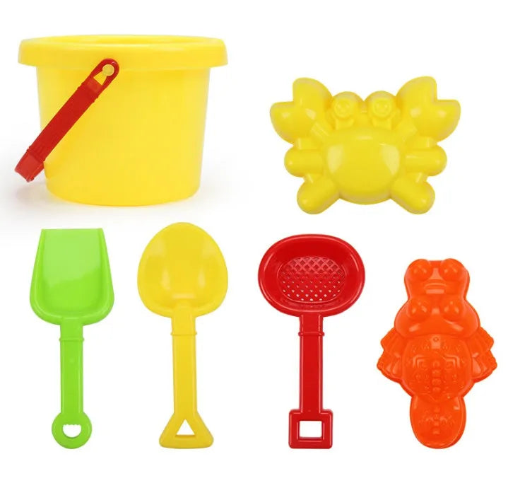 Plastic beach bucket set in sand with bucket and coloured accessories