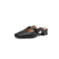 A pair of beige square head low heel slippers with a rubber sole on a wooden deck.