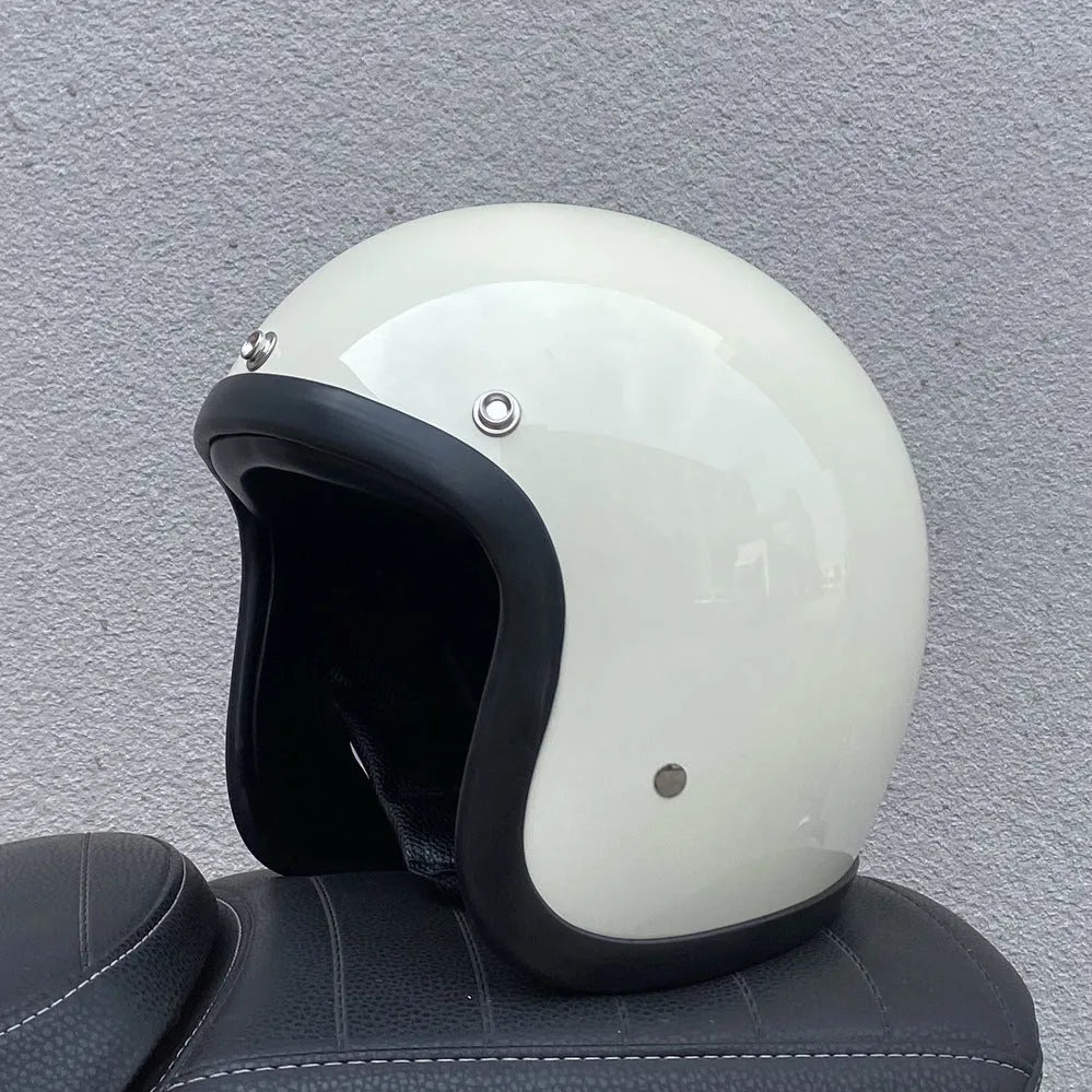 A cement grey retro-style motorcycle half helmet with a floral pattern on the side, showing its open-face design.