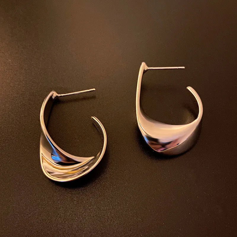 Twisted geometric metal earrings with electroplated gold finish and round design elements