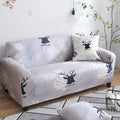 Geometric abstract printed stretch sofa slipcover covering a three-seater sofa with matching cushion covers.