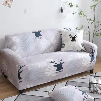 Geometric abstract printed stretch sofa slipcover covering a three-seater sofa with matching cushion covers.