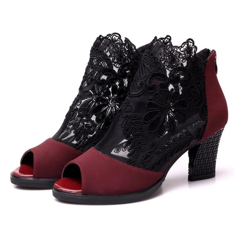 Black women's gladiator sandals with floral lace upper, high square heel, and a front zip closure.