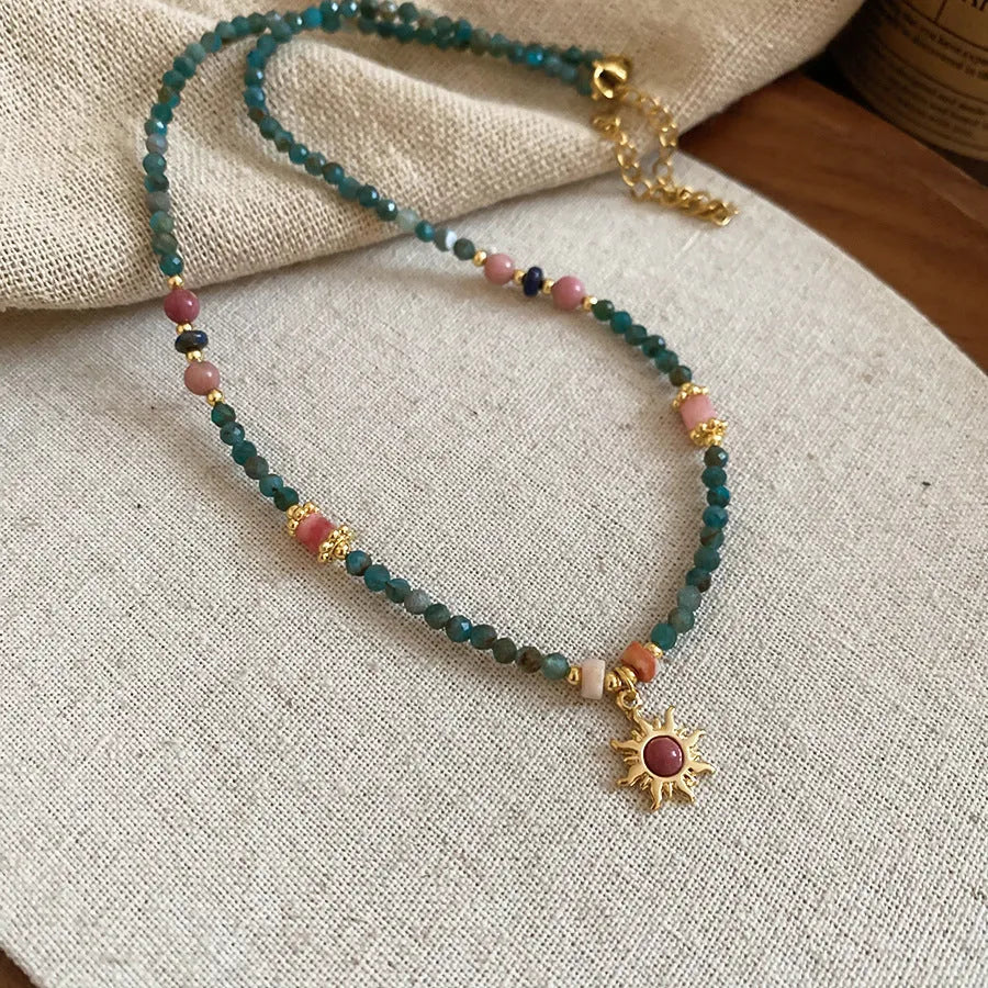 Sun necklace with a stone geometric pendant and freshwater pearls on a clavicle chain.
