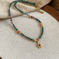 Sun necklace with a stone geometric pendant and freshwater pearls on a clavicle chain.