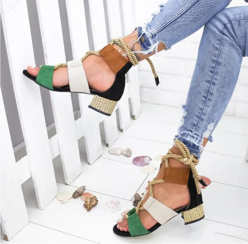 Women's beige suede sandals with thick mid-heel, front strap, and ankle strap on a plain background.