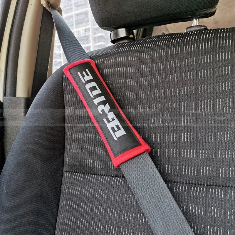 Pair of black car seat belt shoulder pads with embroidery, showing dimensions.