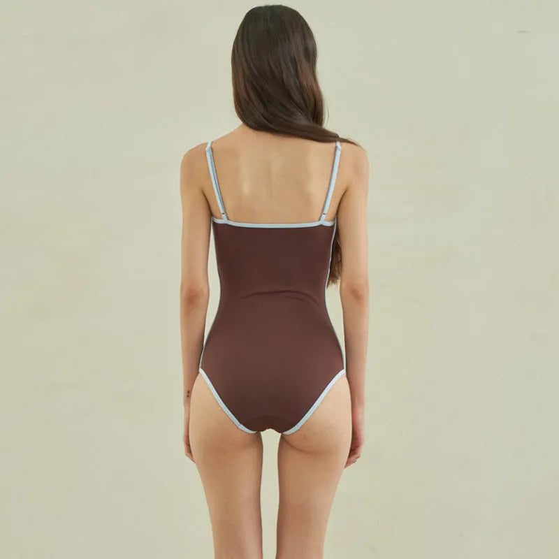 Brown triangle one-piece swimsuit for women on a hanger.
