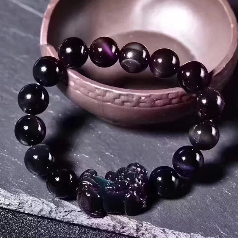 Natural ice colour eye obsidian crystal bracelet on a wrist, showing bead detail.