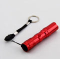Small black aluminium LED flashlight with a strong beam, shown next to a AA battery for scale.