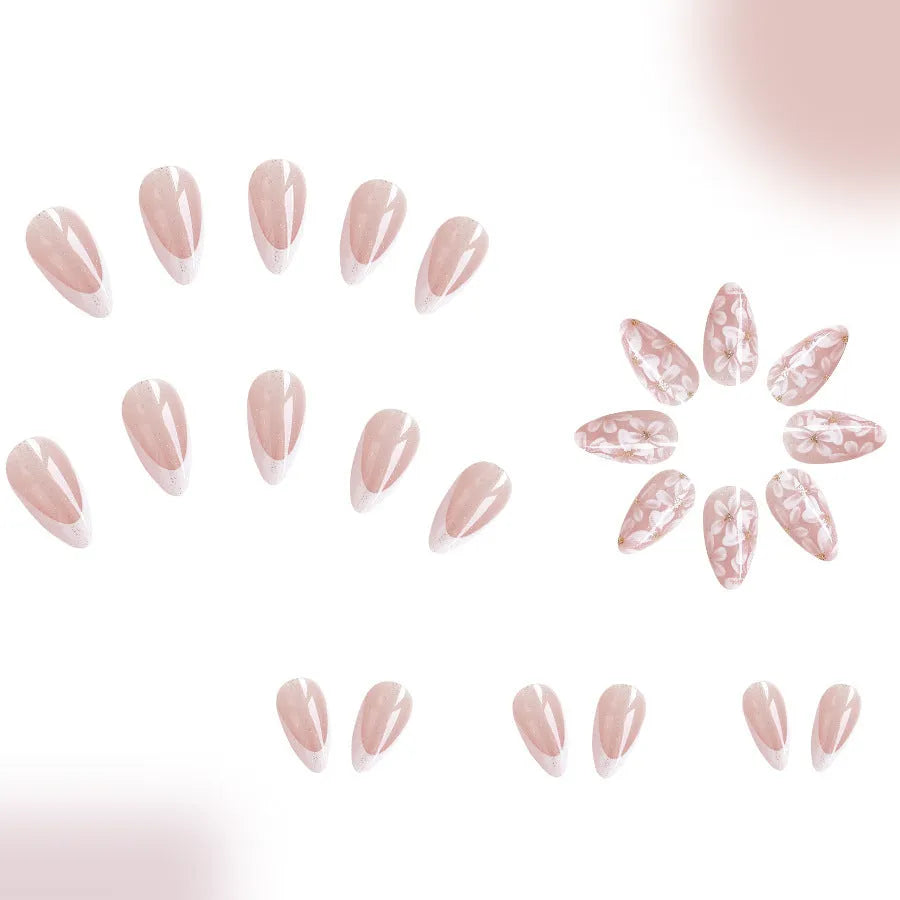Short almond shaped false nails with French style gloss and glittering powder flower accents