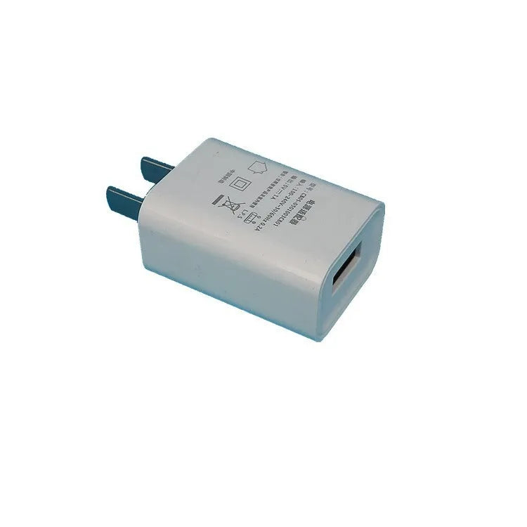 Thin white standard USB power adapter with CE and FCC logos, 5V 1A output.