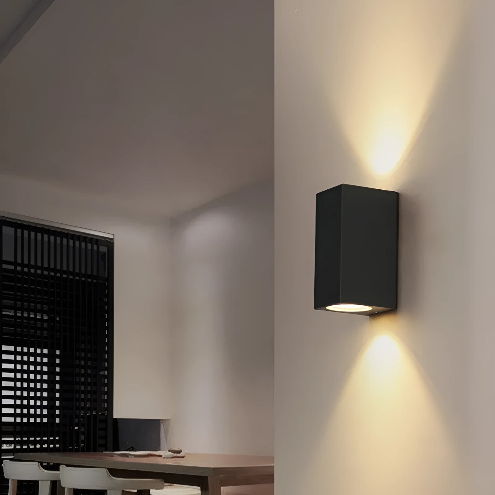Satin black aluminium and glass LED wall lamp mounted on an interior wall.