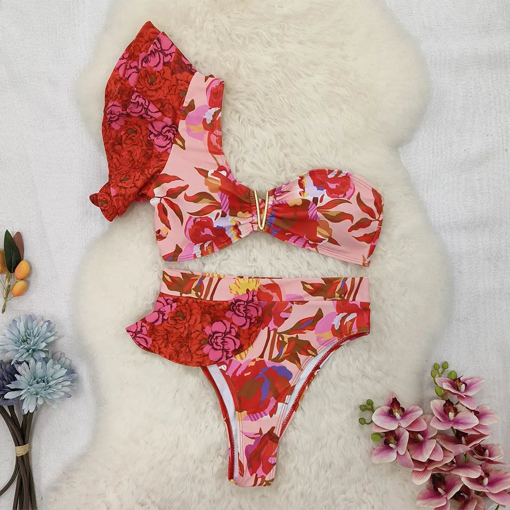 Women's pink floral print one-shoulder bikini with ruffle trim and high-waisted split briefs.