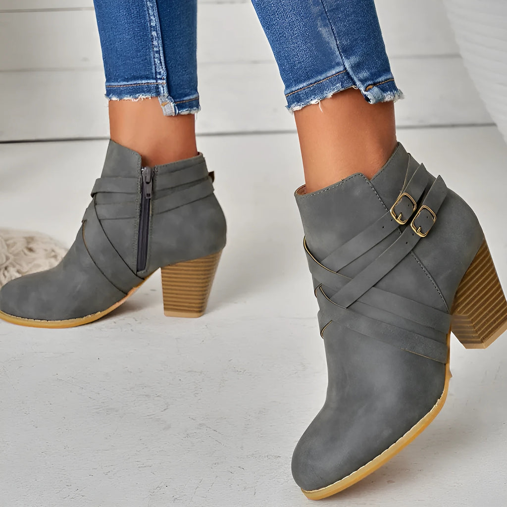 Women's black short boot with 7cm heel, side zipper, belt buckle, and rubber sole