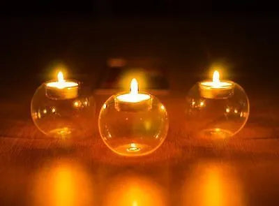 Handmade round hollow clear glass candle holder with a tea light inside, showing European style design.