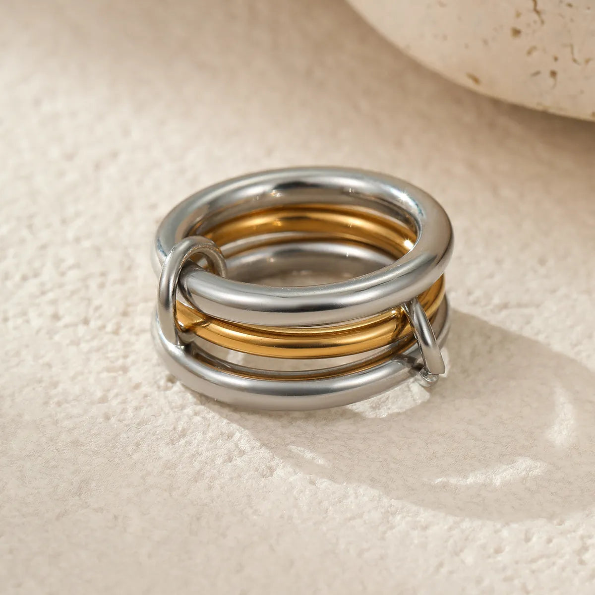 Stacked gold plated stainless steel ring set with exaggerated design on hand