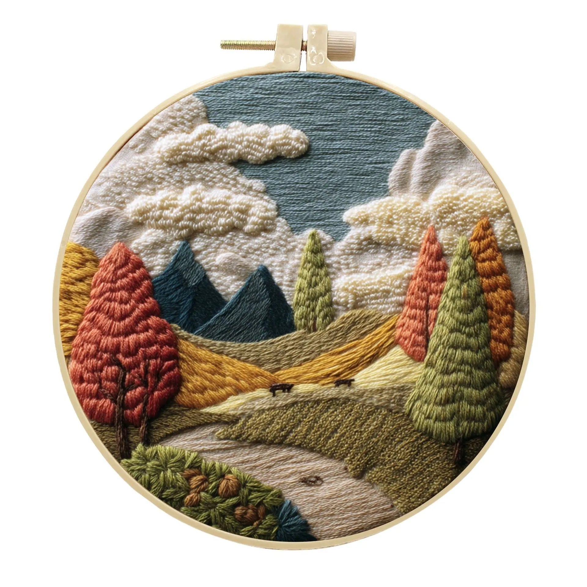 DIY embroidery kit with landscape-printed cotton fabric, embroidery hoop, needles, and coloured thread spools.