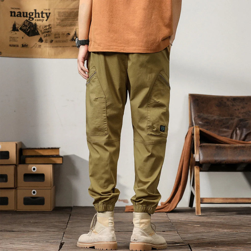 Men's loose khaki cotton harem trousers with tapered leg and ankle banding.