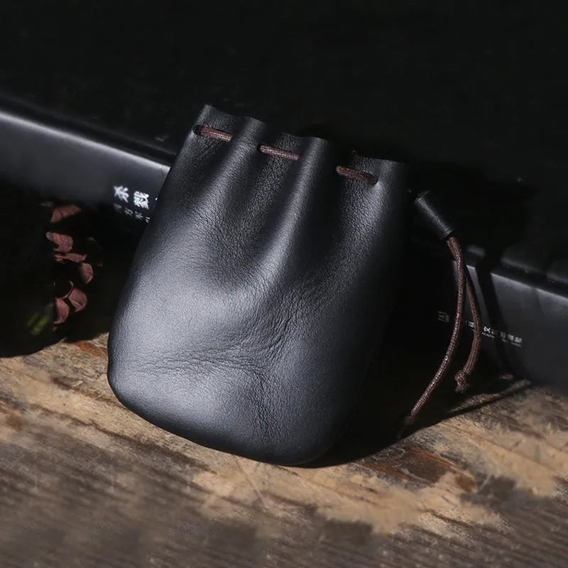 Vintage cowhide drawstring bundle wallet in genuine leather showing retro style and sewing thread detail.