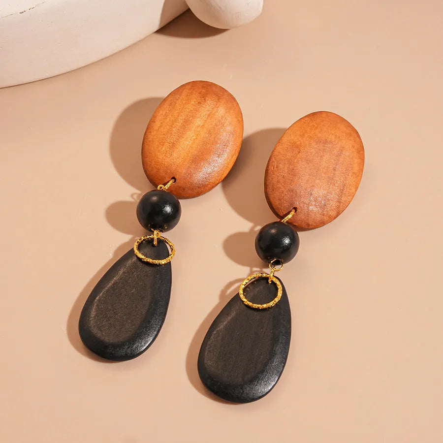 Brown-black wooden earrings with silver needle accents in elliptical European style design