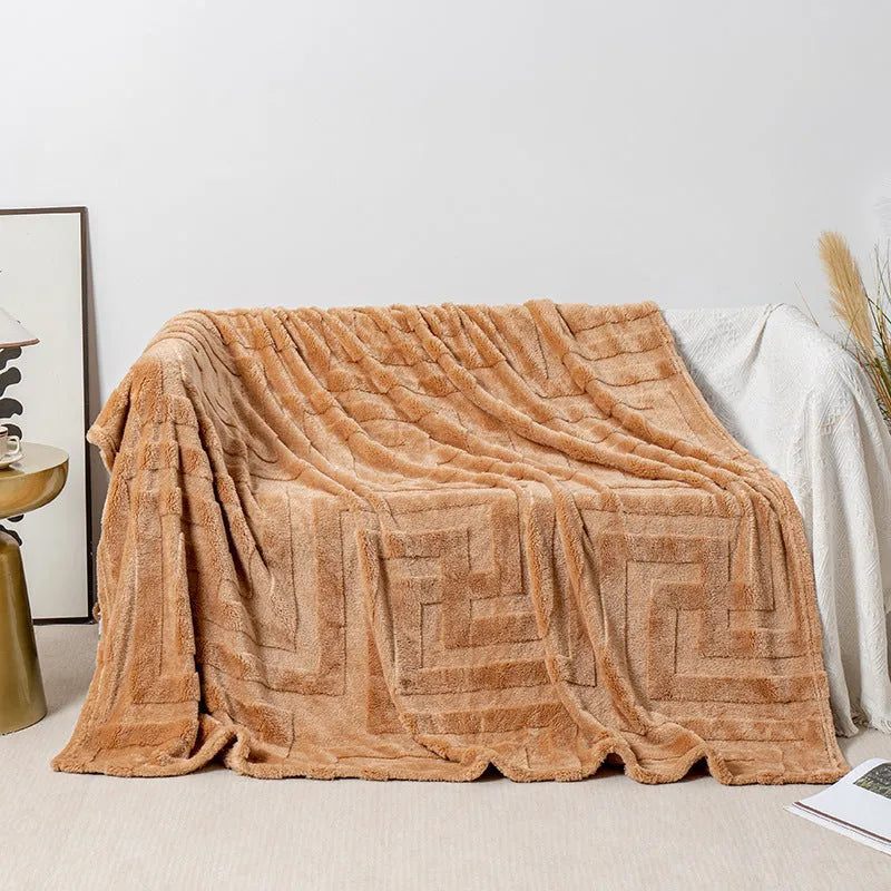 Thick coral fleece sofa blanket in a choice of colours and sizes draped over a grey sofa