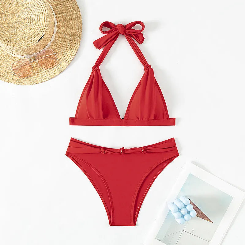 Red women's lace-up halterneck bikini set with split shorts on a mannequin