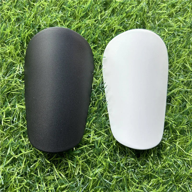 Extra small mini football shin guards in black and white plastic construction