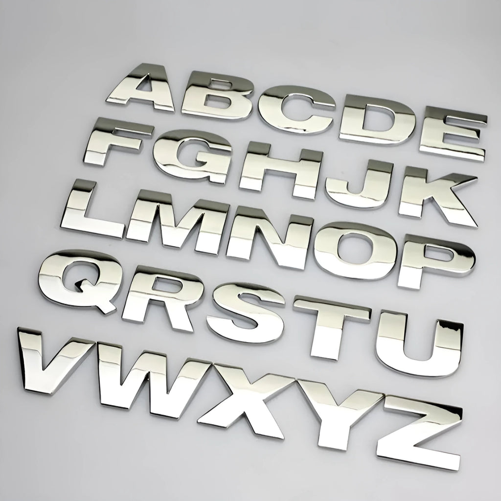Close-up of a silver zinc alloy 3D raised letter 'A' car bumper sticker, approx 2.5cm tall.