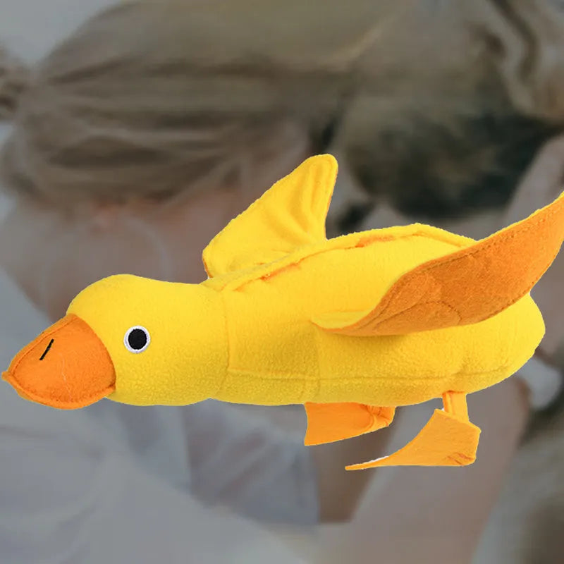 Yellow plush duck dog toy with a sound module and treat-dispensing openings.