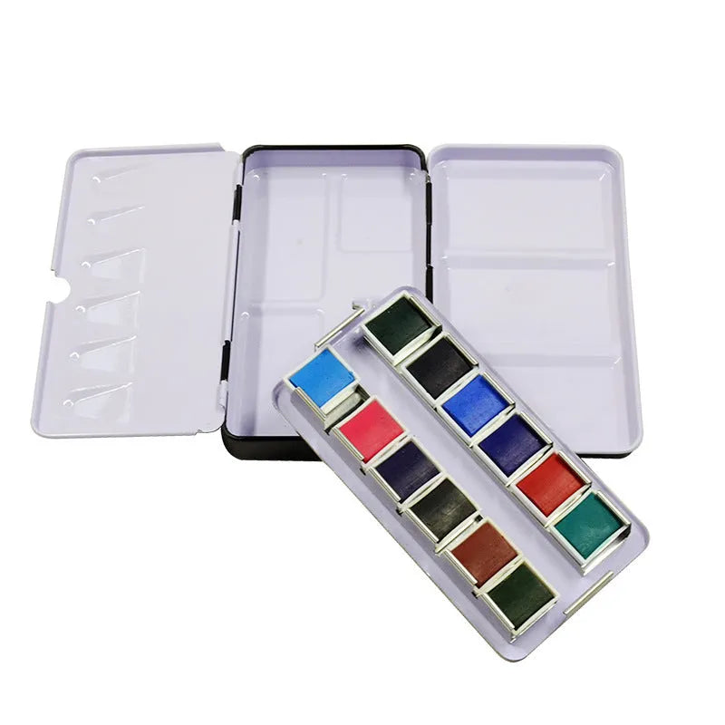 Square tinplate three-fold paint box for solid watercolours, shown open with empty slots.