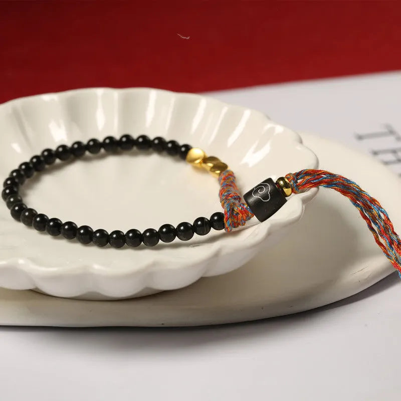 Hand-woven obsidian carrying strap bracelet showing woven texture and 4mm width