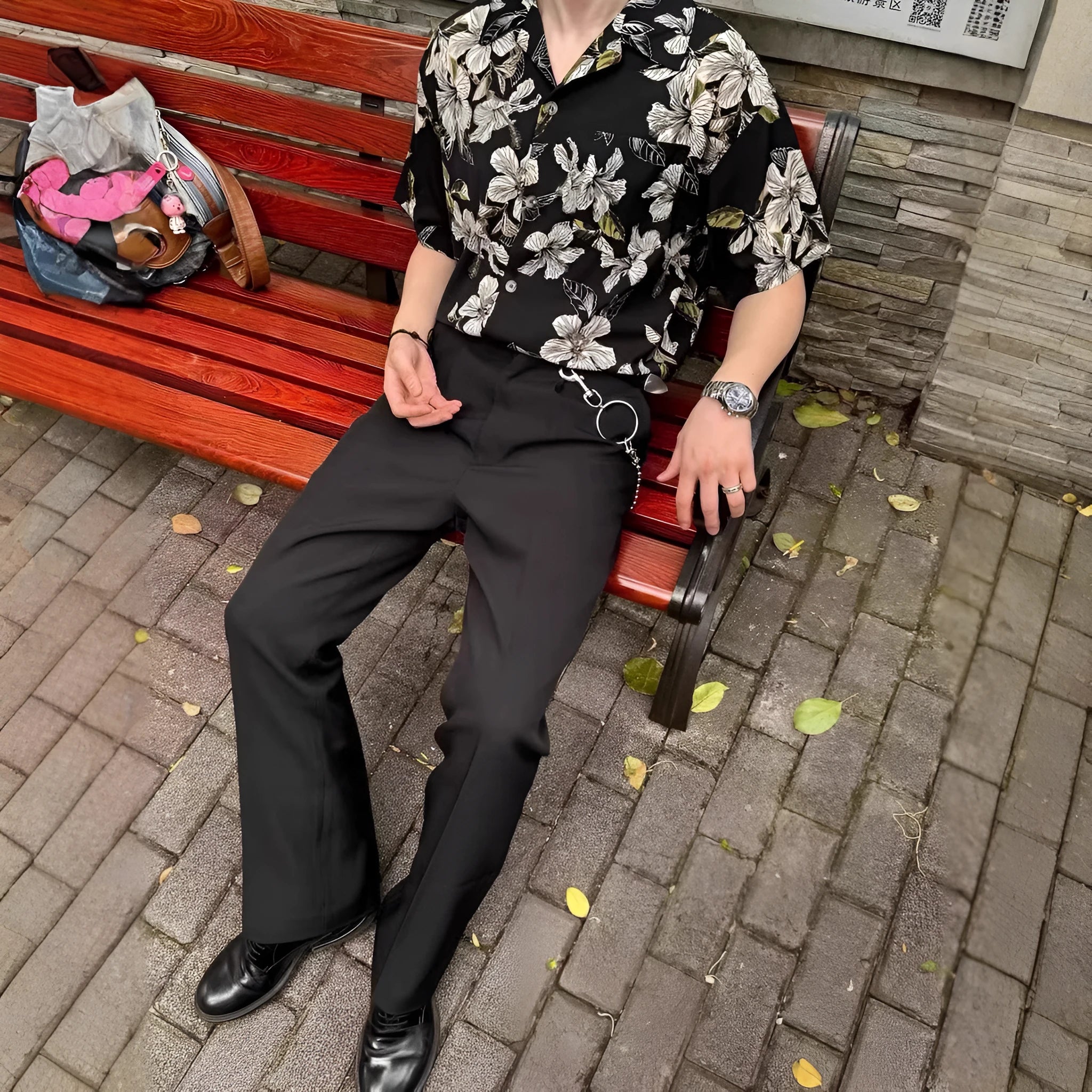 Black men's ice silk shirt with floral print, vintage Cuban collar, and short sleeves on a hanger.