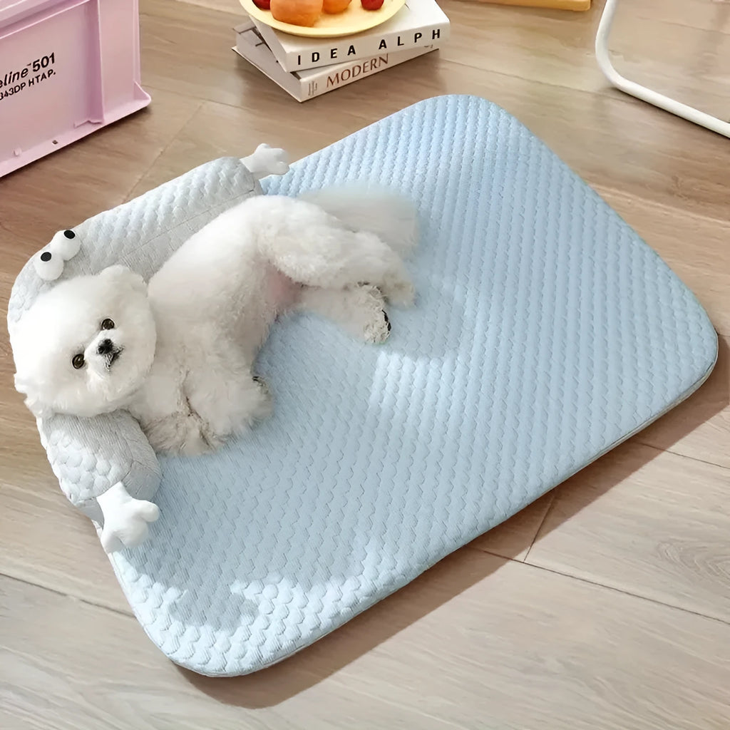 Blue pet bed cushion with cartoon monster face, showing non-slip base and folded size.