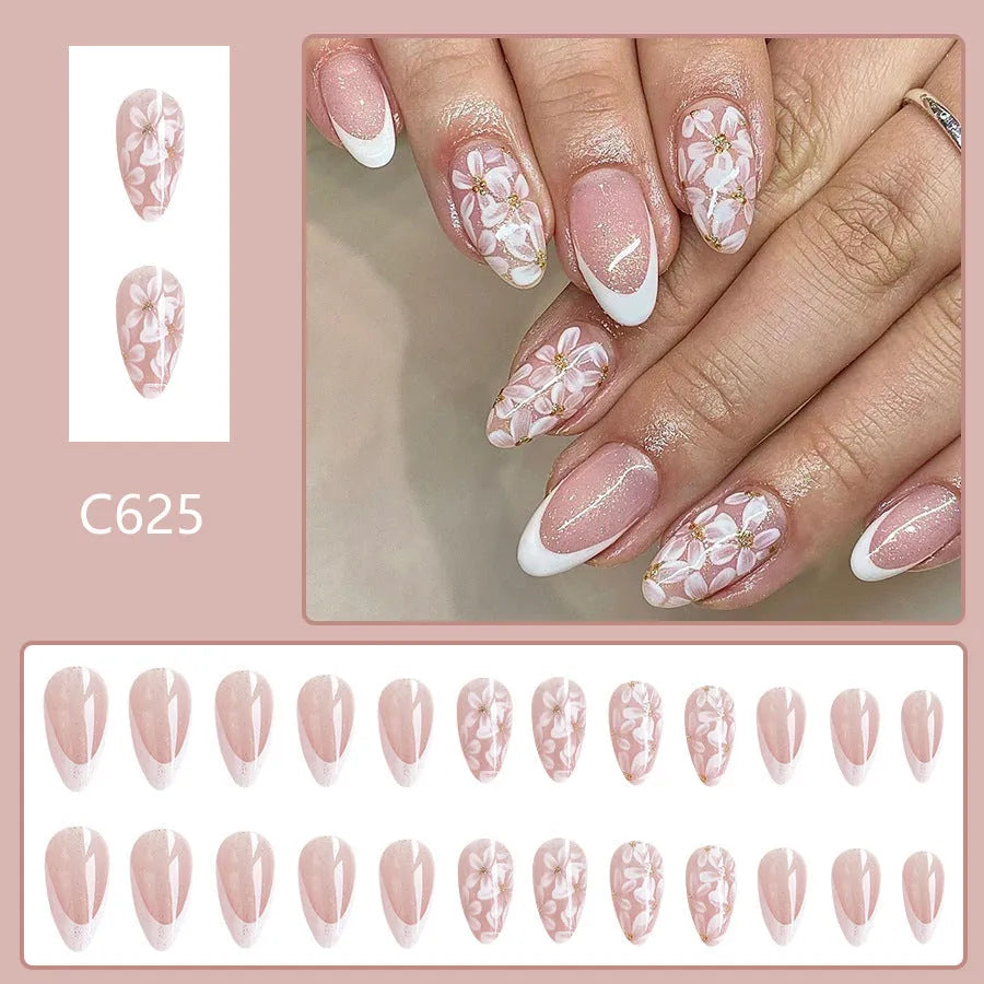 Short almond shaped false nails with French style gloss and glittering powder flower accents