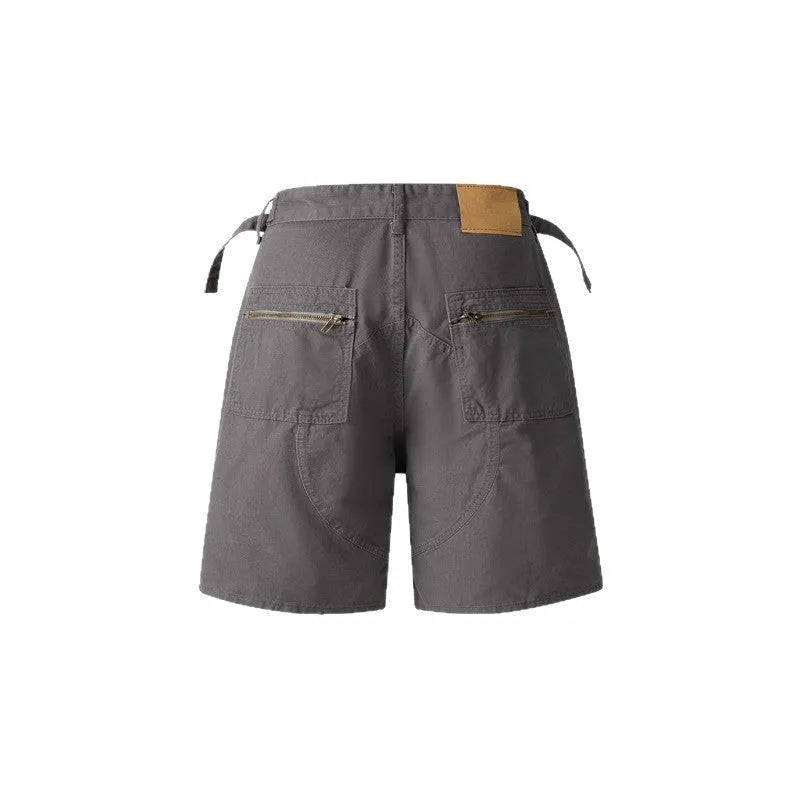 Man wearing grey retro loose-fit washed cotton workwear shorts with a half elastic waistband.