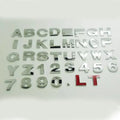 Close-up of a silver zinc alloy 3D raised letter 'A' car bumper sticker, approx 2.5cm tall.
