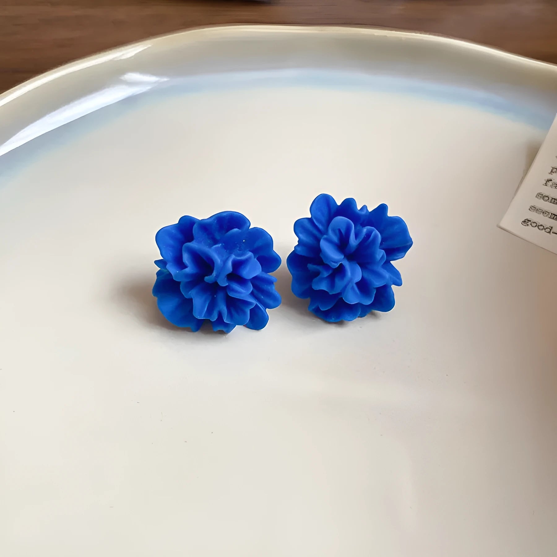 Women's geometric earrings with blue resin flower design on cloth material