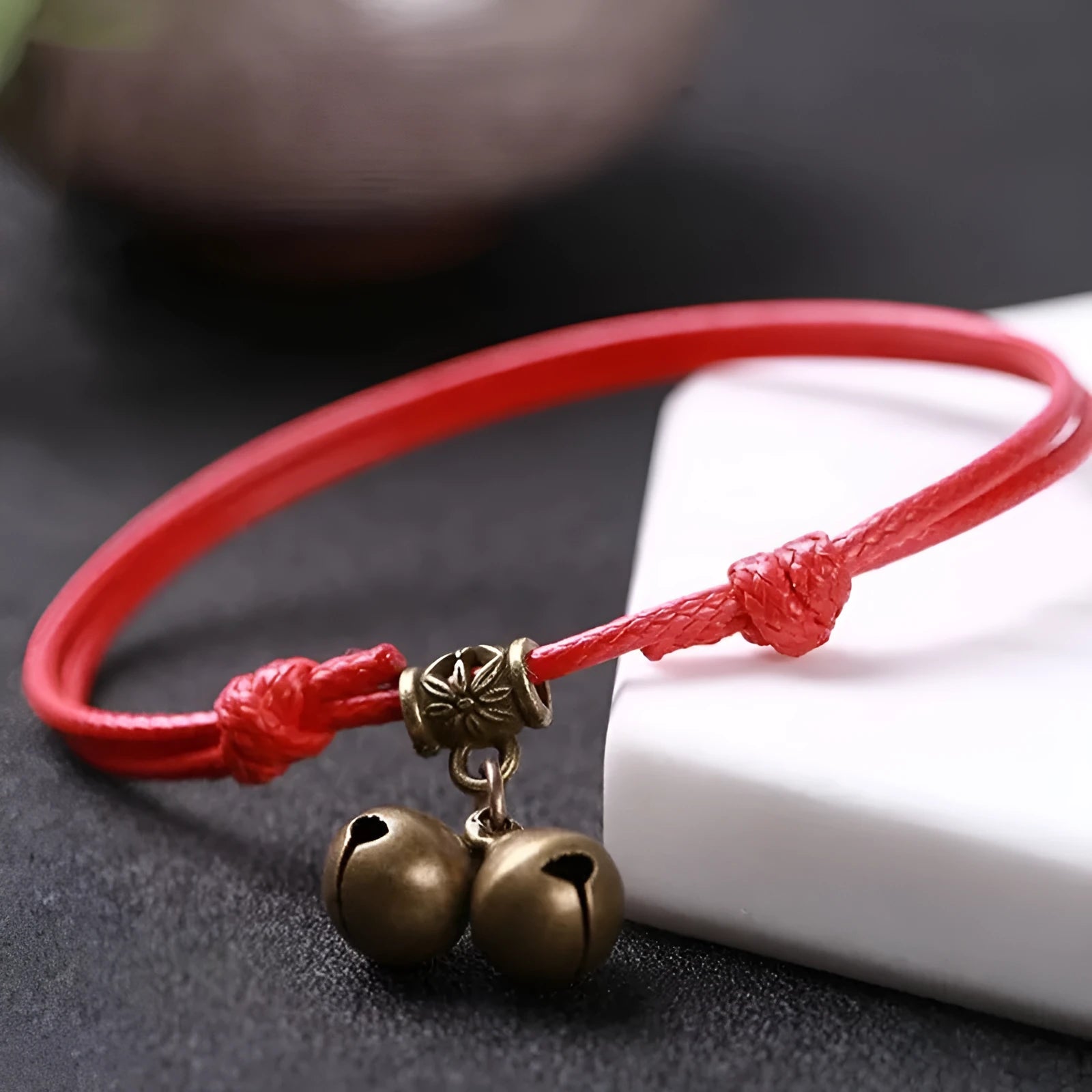 Close-up of a black nylon rope dog collar for small dogs, featuring a shining brass bell.
