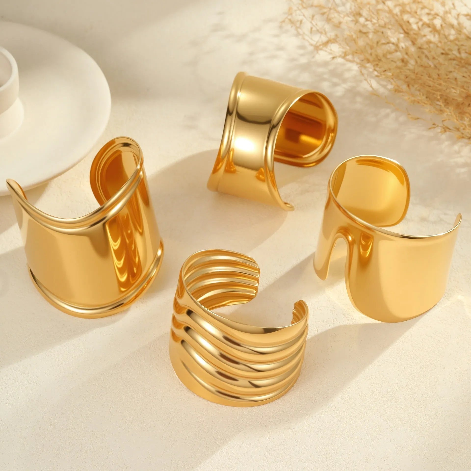 Gold plated stainless steel wide bracelet for women with geometric wave design and niche opening clasp