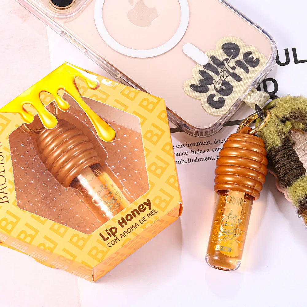 Honey coloured lip gloss on a silver keychain ring against a plain background.