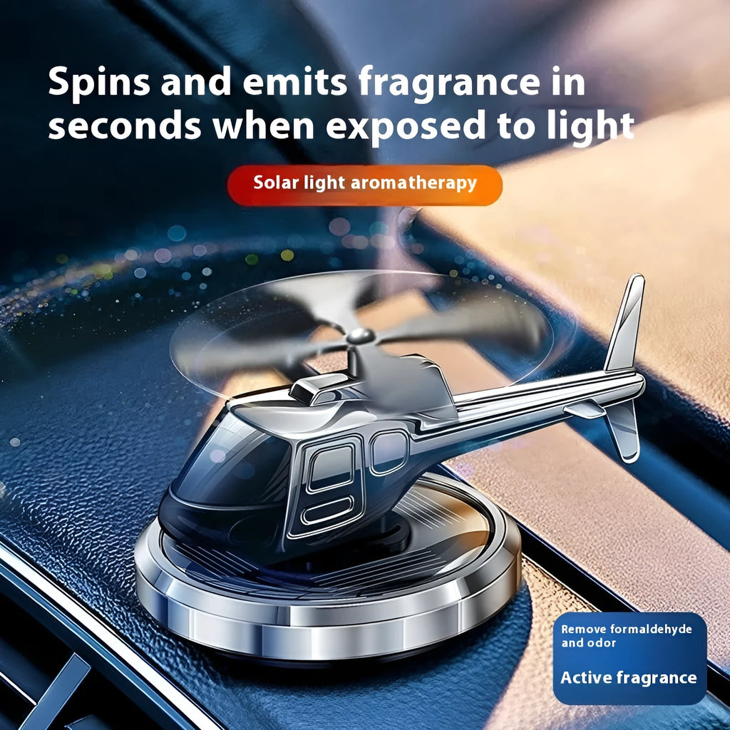 Silver metal solar-powered rotating helicopter car perfume ornament on dashboard