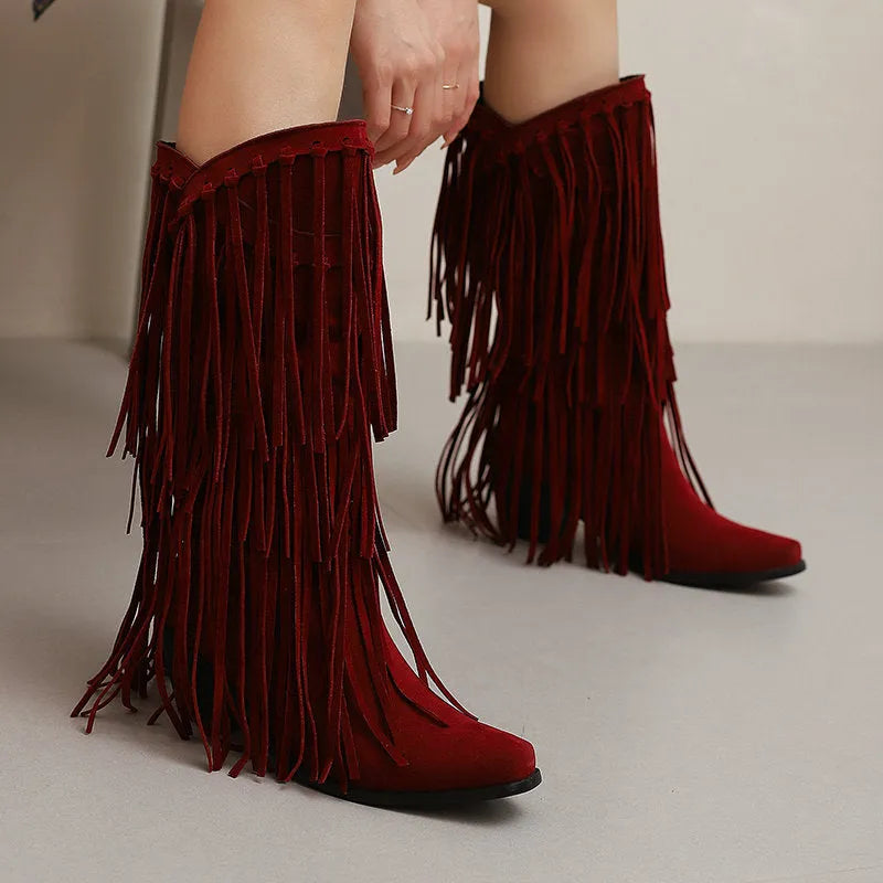 Women's black suede knee-high boots with a chunky heel and tassel decoration.