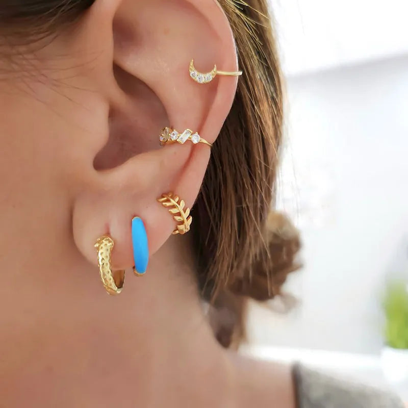 Geometric U-shaped silver wire drop earrings with glossy oval epoxy resin elements in various colours.