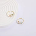 Gold geometric women's ring with horse eye design and three coloured zircon stones on a triangular band.