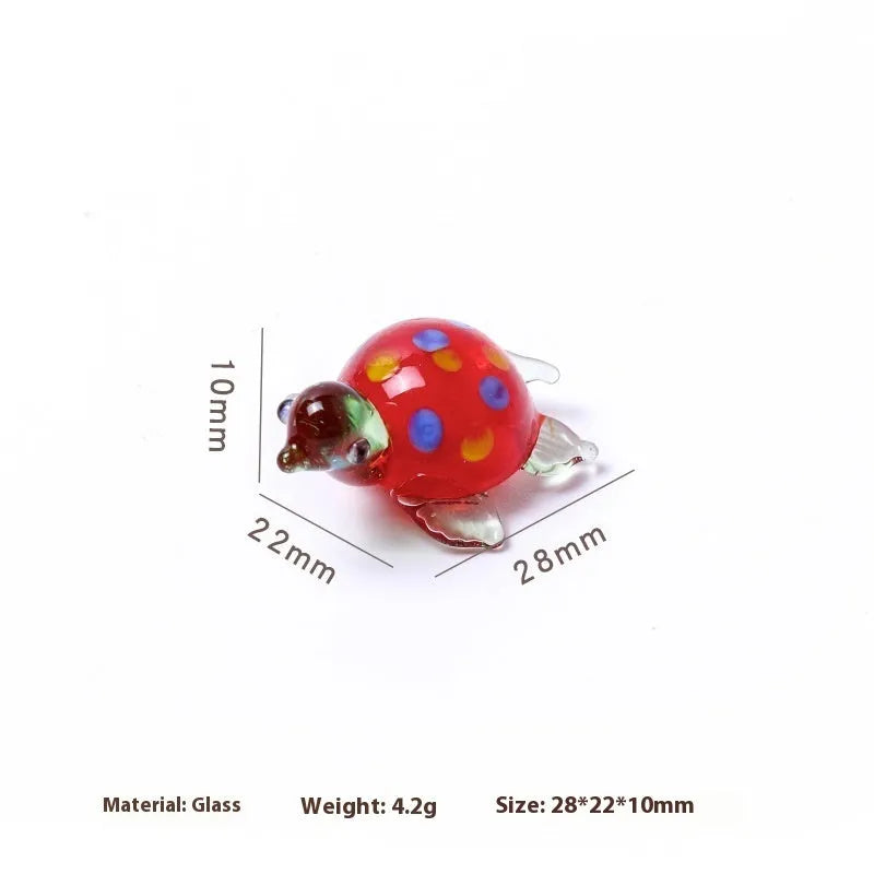 Geometric glass turtle ornament in a modern style with a coloured shell, displayed on a desktop.