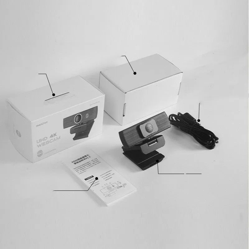 Black USB webcam with attached cable and a magnetic privacy cover on a desk.