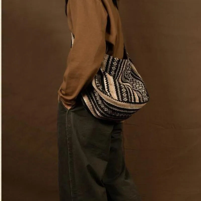 Corduroy vintage messenger bag with jacquard stripes, handprint detail, and an adjustable plaid shoulder strap.