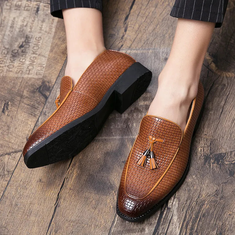 Men's black pointed toe slip on shoes with a gold tassel detail on the upper.