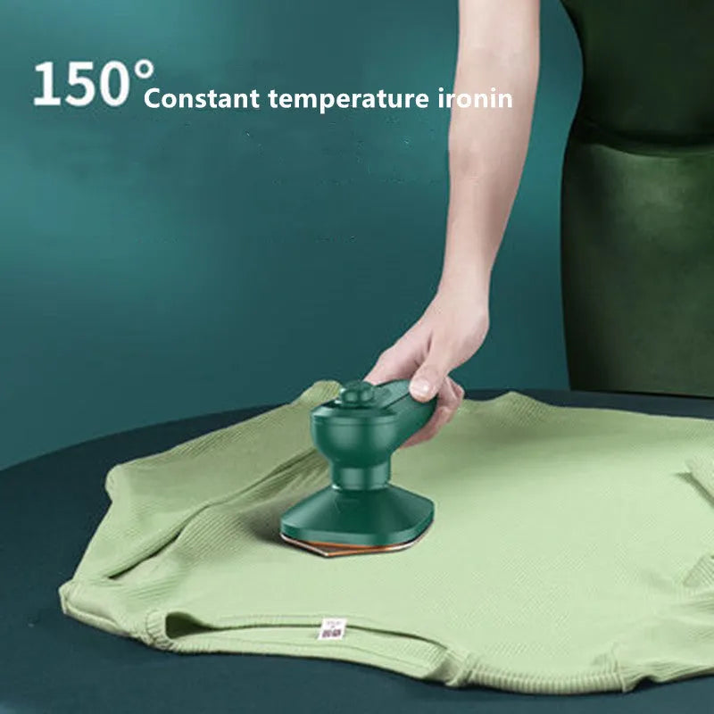 Dark green portable hand-held hanging steam ironing machine with a ceramic panel, shown with a power plug.
